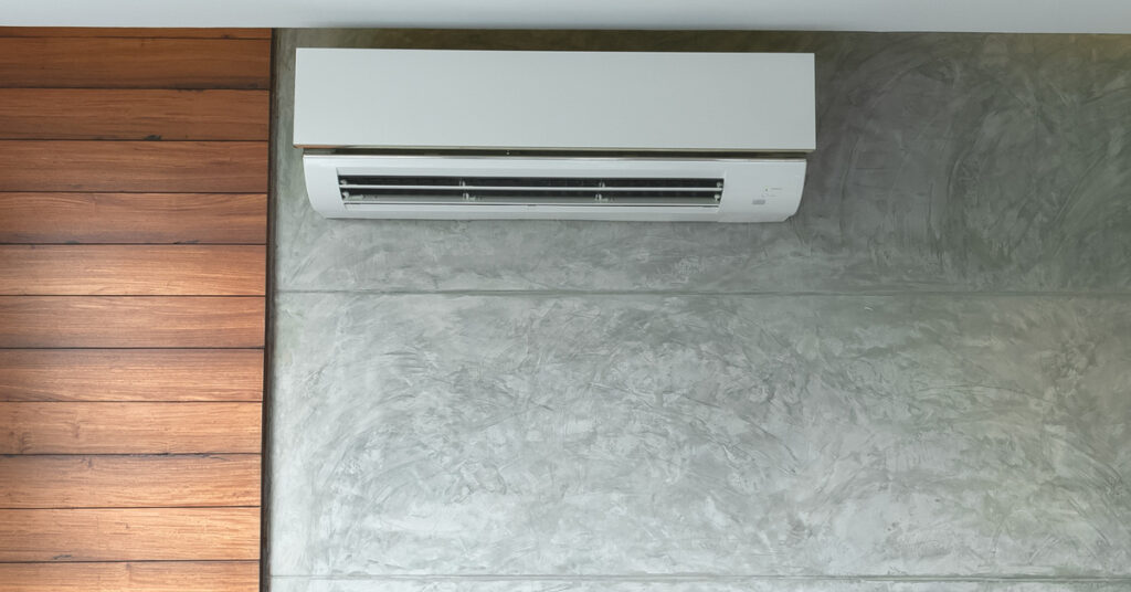 The interior of a home with wooden and linoleum walls has a ductless HVAC unit near the ceiling.